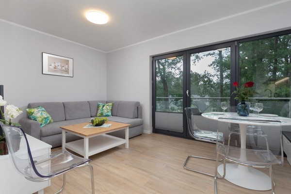 The living area features a sleek coffee table and a flat-screen television.