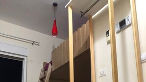 A bunk bed room with a ladder, a red hanging light, and a white wall with a power outlet. - Studio Residence LES DUNES Kantaoui Sousse  (Hammam Sousse)