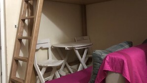 A bunk bed with a wooden ladder, a small white table, and a couch with a pink blanket. - Studio Residence LES DUNES Kantaoui Sousse  (Hammam Sousse)