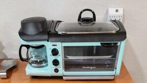 A kitchen with a toaster oven on the counter, a coffee maker, and a drawer with kitchen utensils. - #28 Little Belleview by Joyful Moments Vacation (Port Richey)