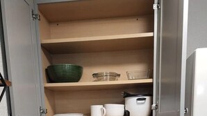 A compact kitchen with a sink, countertop, and open cabinets. - #28 Little Belleview by Joyful Moments Vacation (Port Richey)
