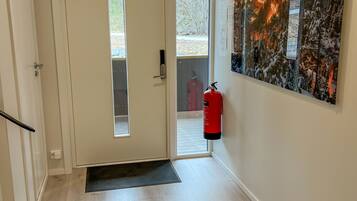 Ein Flur mit einer Tür, einem Feuerlöscher und einem an der Wand befestigten Schild.