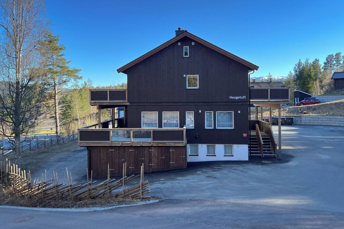 En tvåvåningsbyggnad med en skylt där det står ”Haugetuft”.