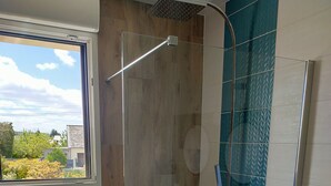 A modern bathroom with a glass shower enclosure, a window, and a view of the outdoors. - Detached house near SAINT MALO (Miniac-Morvan)