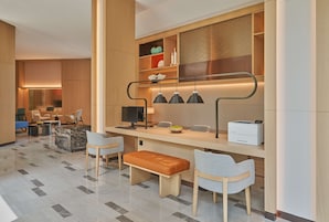 Un moderno vestíbulo de hotel con mostrador de recepción, zona de estar y un amplio ventanal.