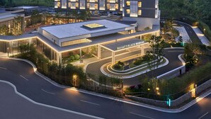 Un hôtel moderne à plusieurs étages, doté d’une terrasse sur le toit et d’une entrée bien éclairée.