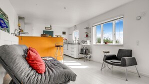 Een modern appartement met een zithoek, keuken en eethoek.