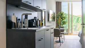 Une cuisine moderne dotée d’une cuisinière intégrée, d’un évier et d’un coin repas avec une chaise et une table.