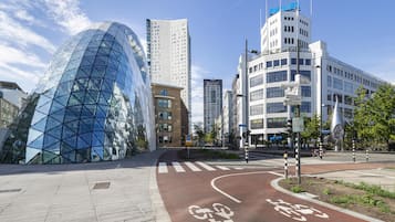 Una calle urbana moderna con un edificio de vidrio, un carril bici y varios edificios comerciales, incluyendo el museo Philips.