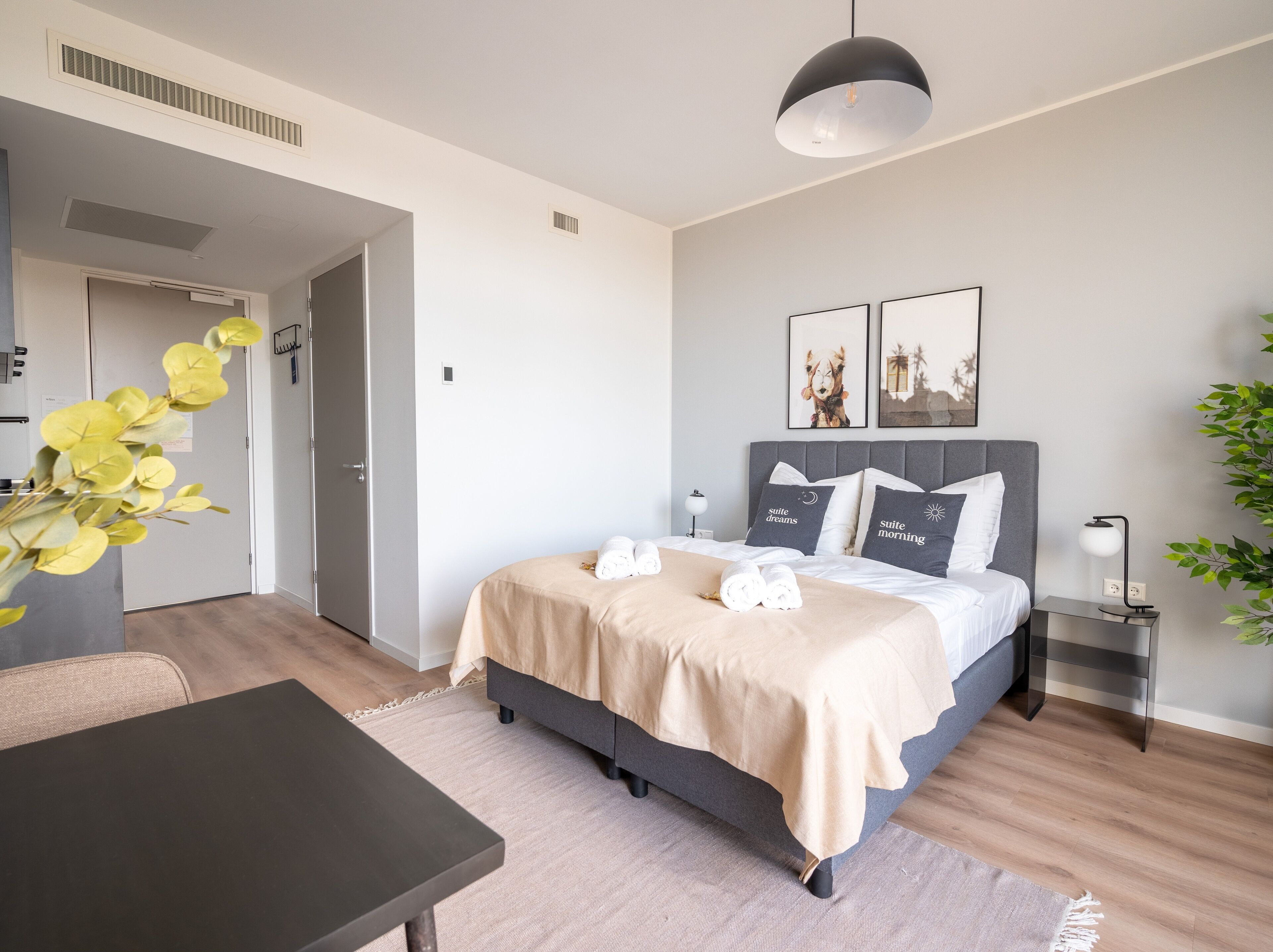 Una habitación de hotel moderna con una cama, mesitas de noche, un escritorio y una silla.