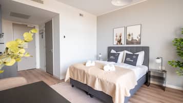 Una habitación de hotel moderna con una cama, mesitas de noche, un escritorio y una silla.