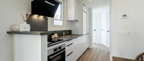 A modern kitchen with a built-in oven, a microwave, and a sink.