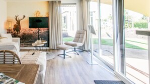 A modern living room with a large window, a sofa, a chair, and a decorative deer head. - Nice home in Voorthuizen with WiFi (Voorthuizen)
