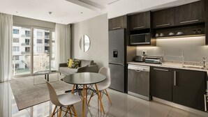 Eine moderne Wohnung mit Essbereich, Küche und großen Fenstern mit Stadtblick.