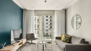 Ein modernes Wohnzimmer mit Fernseher, Sofa und Couchtisch.