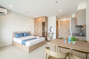 Une chambre moderne avec un lit en bois, une petite table de chevet et une armoire intégrée.
