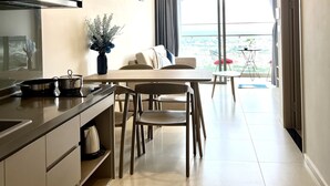 A modern kitchen with a dining area, a large window, and a view of the outdoors.