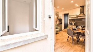 Una cocina moderna con comedor, suelo de madera y ventana con vistas al interior.