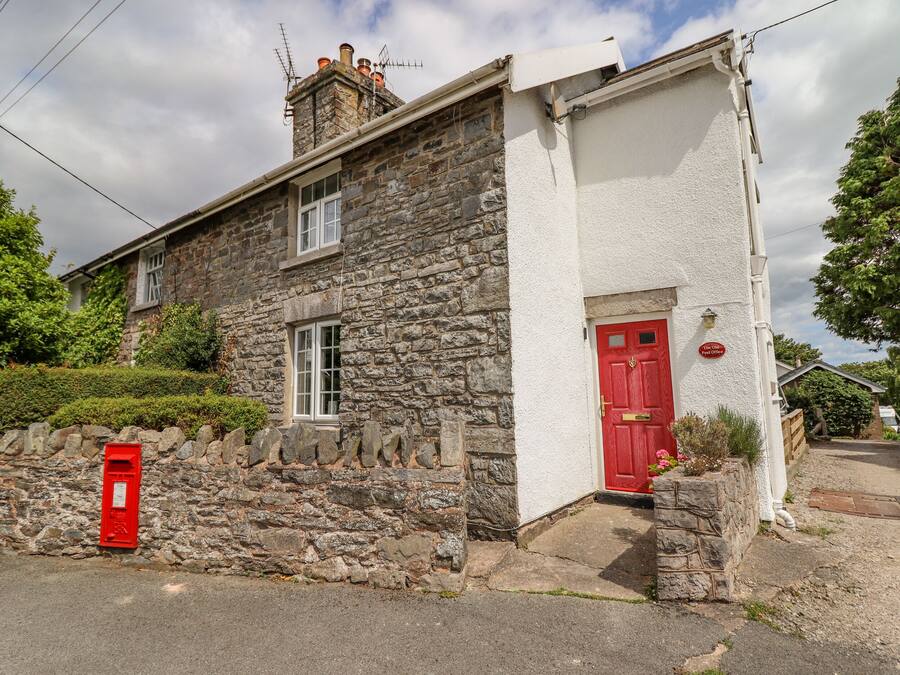 A stone house with a red door and a mailbox.