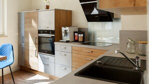 A modern kitchen with a built-in oven, a coffee machine, and a sink. - Fewo für die Familie Dachterrasse Trocker/waschmaschine Netflix Jarody (Senheim (Mosel))
