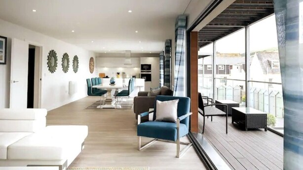 A spacious living area with a balcony, modern furniture, and a view of the city. - This Apartment is No Longer Available (Woolacombe)