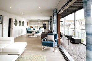 A spacious living area with a balcony, modern furniture, and a view of the city. - This Apartment is No Longer Available (Woolacombe)