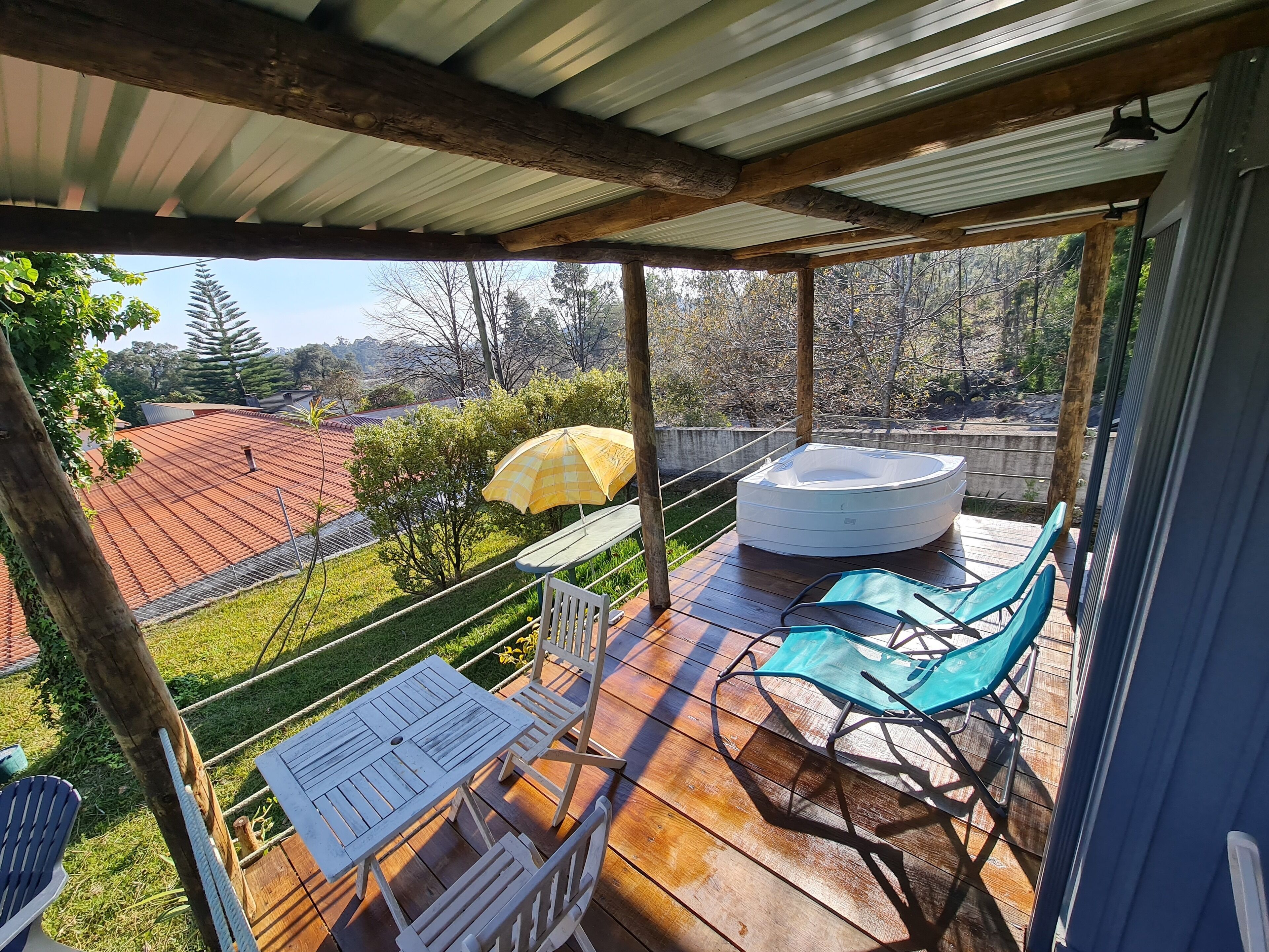 Un espace extérieur abrité comprenant un jacuzzi, des chaises et une table.
