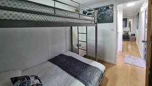 A bunk bed room with a ladder, a bedside table, and a wall-mounted TV. - CHALET DESIGN NATURA JACUZZI GUEST DREAM (Esposende)