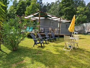 Relax in a serene outdoor space surrounded by lush greenery and a wooden pergola.