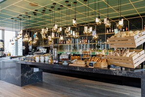 A bakery counter with various breads, pastries, and a coffee machine.