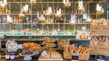 A bakery display with various breads, pastries, and desserts.