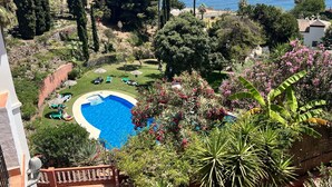 Une piscine entourée d’une végétation luxuriante, avec vue sur la mer.