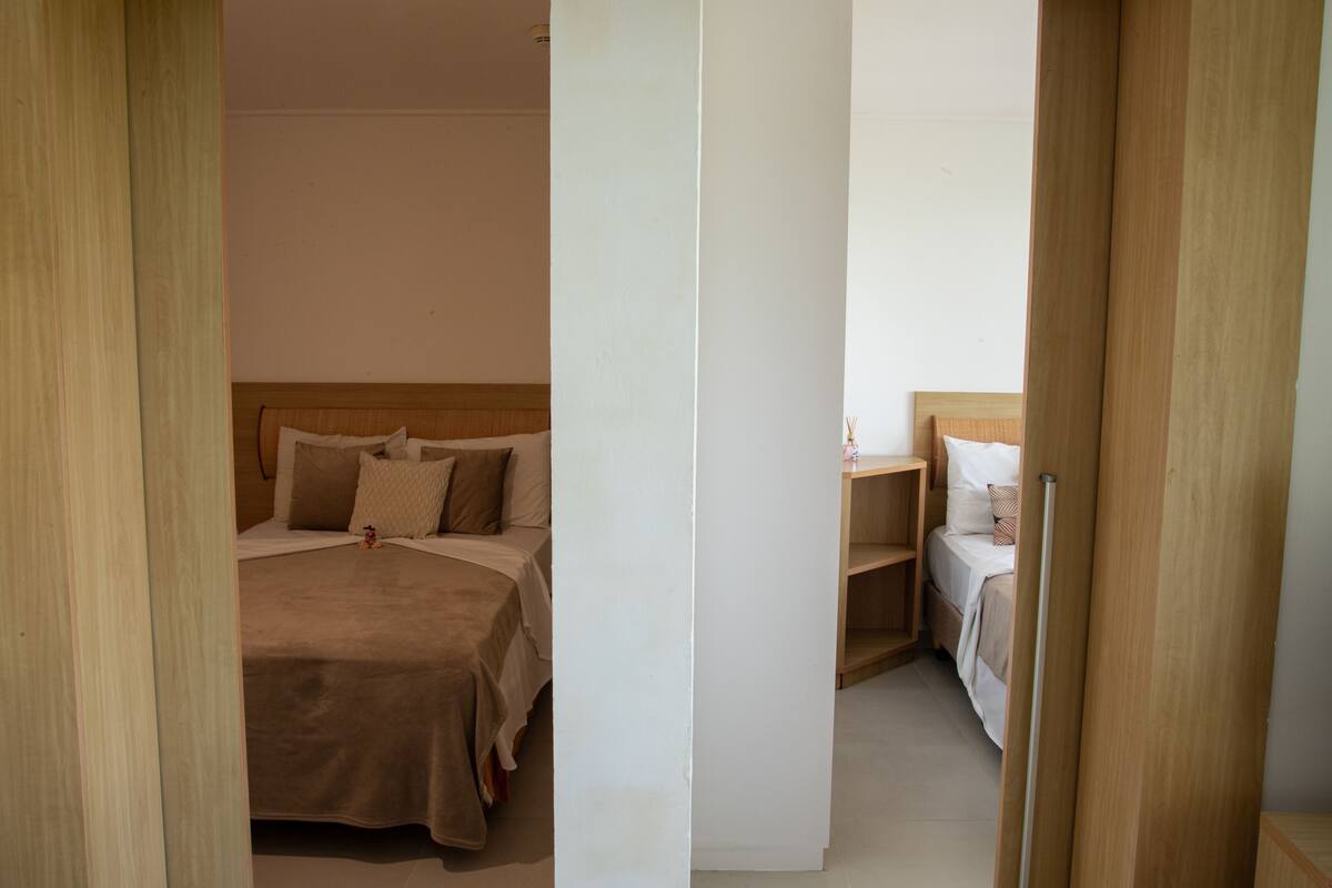 A bedroom with a bed, bedside tables, and a nightstand.