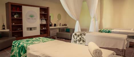 Una sala spa con due lettini da massaggio, una reception e un display a parete.