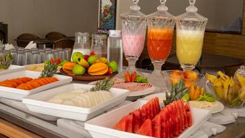 A buffet with various fruits, vegetables, and beverages.