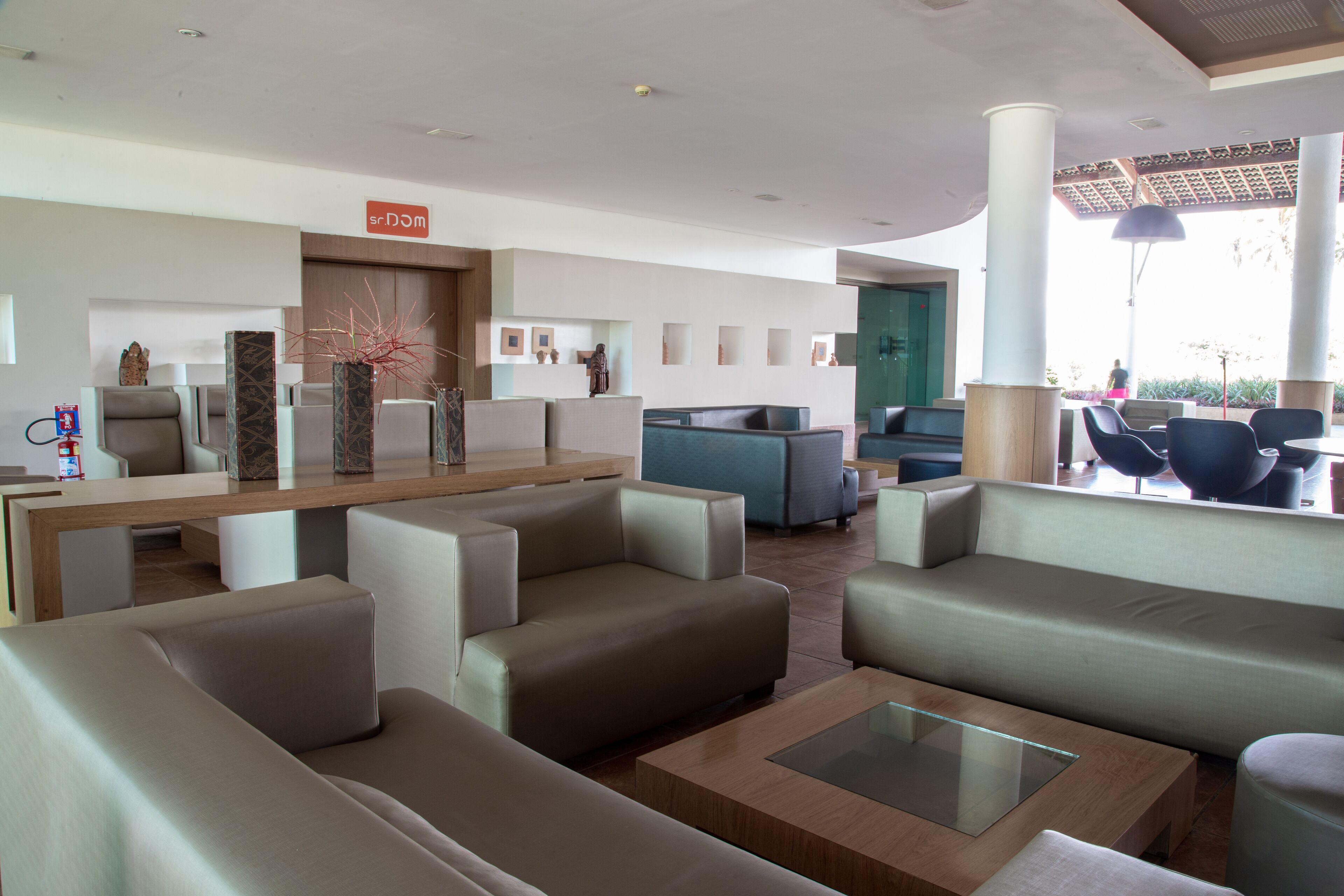 A modern lobby with sofas, a reception desk, and a seating area.