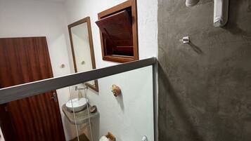 Un baño con inodoro, lavamanos y ducha.
