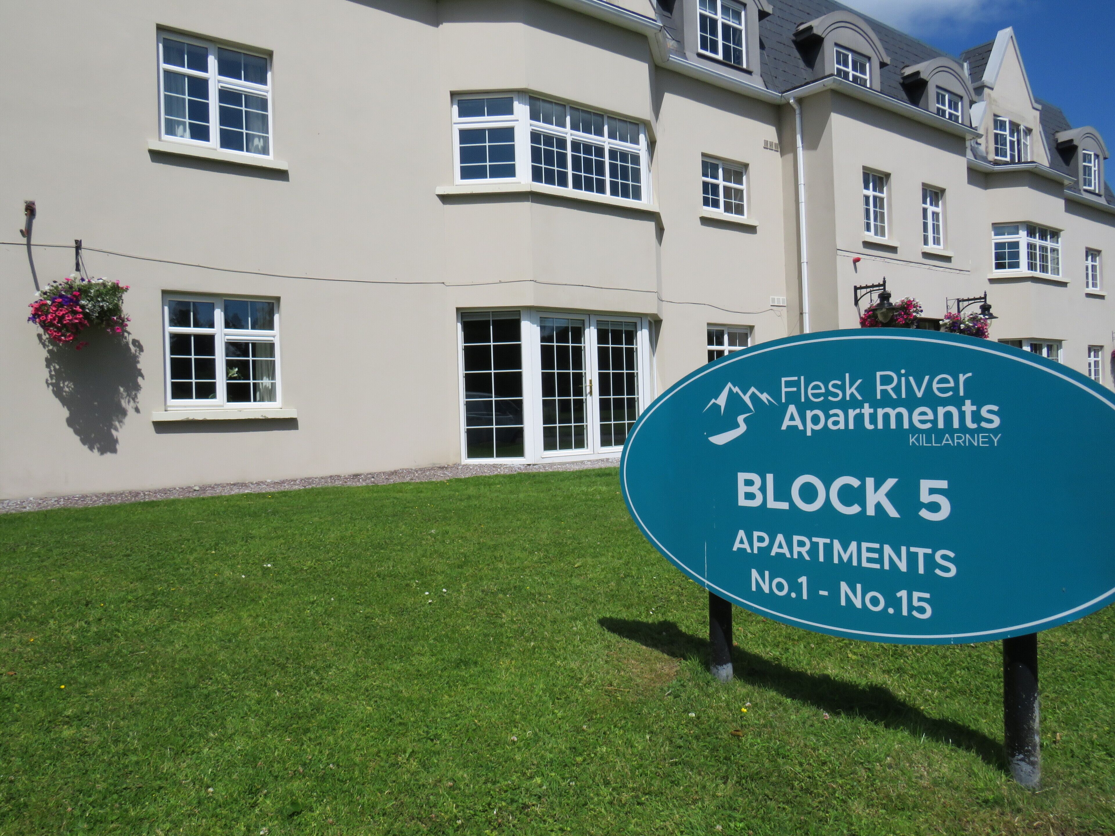 A sign for Flesk River Apartments, Block 5, with apartment numbers 1 to 15.