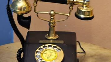 Un teléfono antiguo de disco giratorio sobre una mesa de madera.