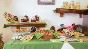 Un bufé de desayuno con diversos pasteles, pan y salsas.