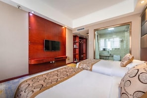 Ein Hotelzimmer mit einem großen Bett, einem an einer Holzpaneelwand montierten Fernseher, einer Glasdusche und einem Kleiderschrank.