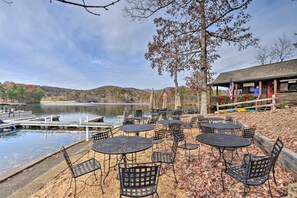Sit and enjoy the serene lake views from this lakeside seating area, surrounded by a deck and trees with vibrant foliage.