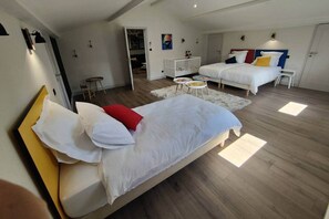 A modern hotel room with two beds, a crib, and a small dining area. - Magnificent villa with swimming pool and gym (Aubenas)