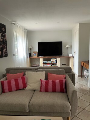 A living room with a sofa, television, and a small table.