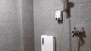 Uma área de chuveiro com painel de controle e chuveiro manual.