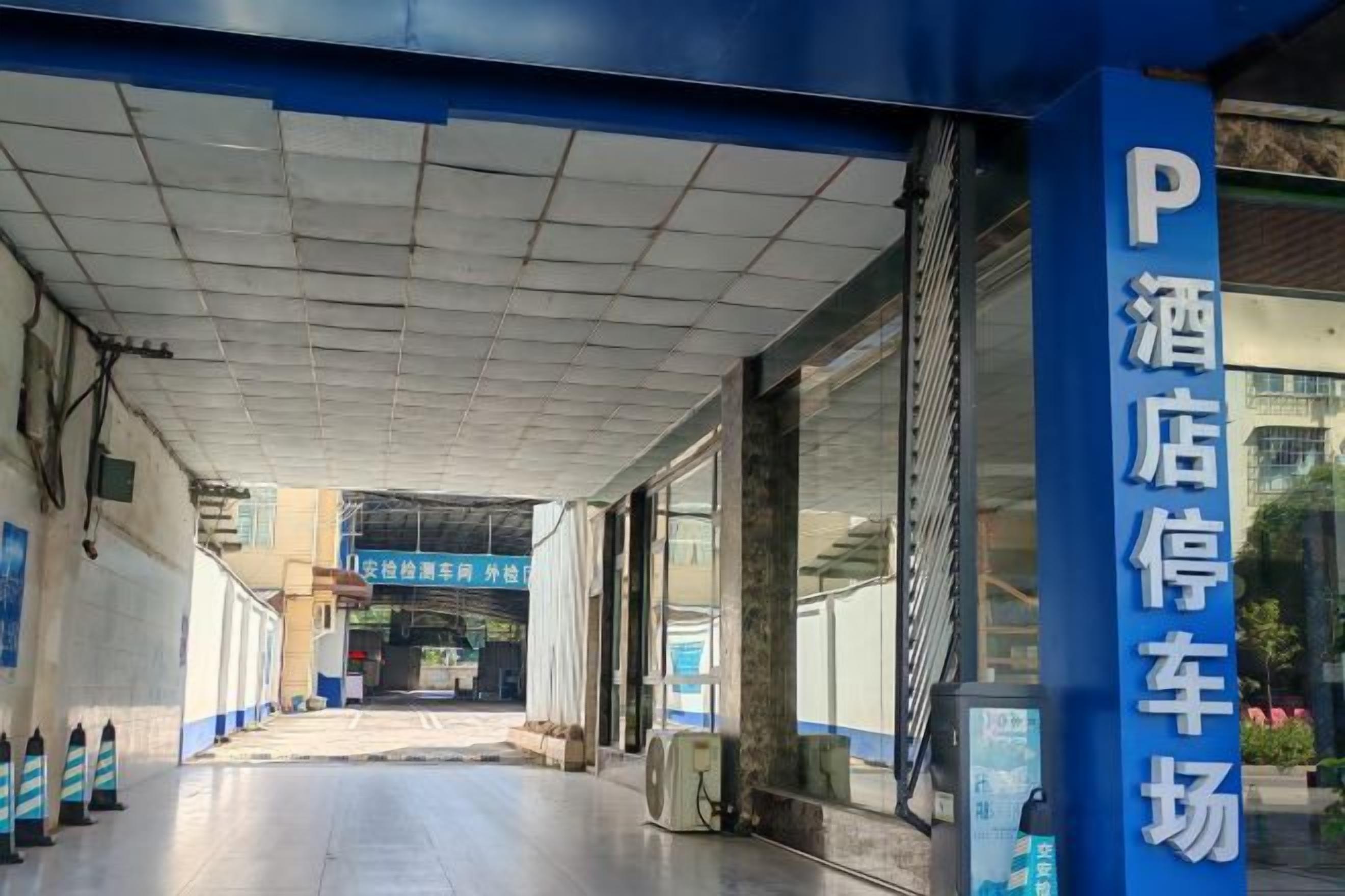 Un espace de stationnement d’hôtel avec un chemin dégagé menant à l’entrée.