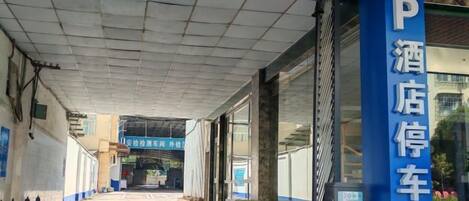 Un espace de stationnement d’hôtel avec un chemin dégagé menant à l’entrée.