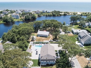 A residential area with houses, a swimming pool, and a lake.
