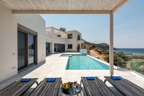 Une villa moderne dotée d’une piscine, d’un espace extérieur aménagé et offrant une vue imprenable sur la mer.