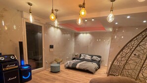 Een moderne slaapkamer met een bed, een stoel en een Marshall-versterker.